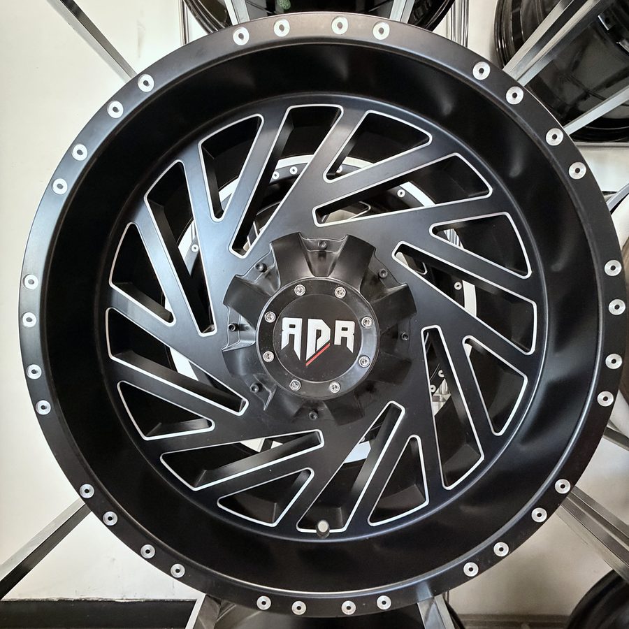 ADR satin black milled truck wheel with directional turbine spokes and simulated beadlock ring, in stock at Llantera Del Norte INC, 606 Peoria St, Aurora, Colorado / Rin de camioneta ADR negro satinado con rayos direccionales tipo turbina y anillo beadlock simulado, disponible en Llantera Del Norte INC en Aurora, Colorado