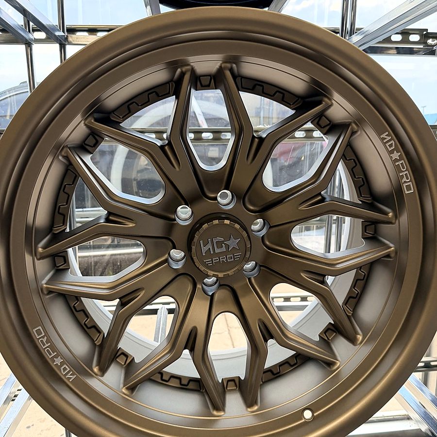 HD Pro bronze multi-spoke custom wheel on the wheel wall at Llantera Del Norte INC, 606 Peoria St, Aurora, Colorado / Rin personalizado HD Pro en bronce de rayos múltiples en Llantera Del Norte INC en Aurora, Colorado