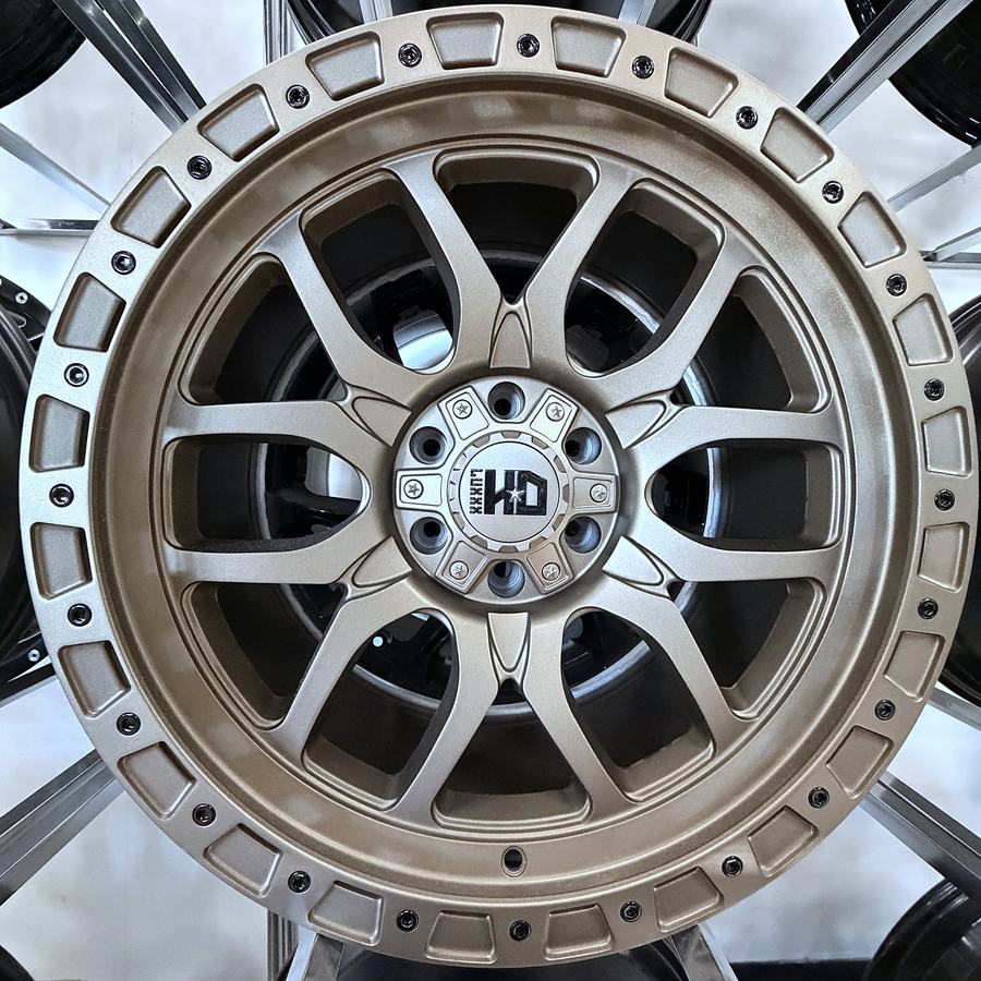 Luxxx HD bronze truck wheel with simulated beadlock ring and eight-spoke design, in stock at Llantera Del Norte INC, 606 Peoria St, Aurora, Colorado / Rin de camioneta Luxxx HD en bronce con anillo tipo beadlock simulado y ocho rayos, disponible en Llantera Del Norte INC en Aurora, Colorado